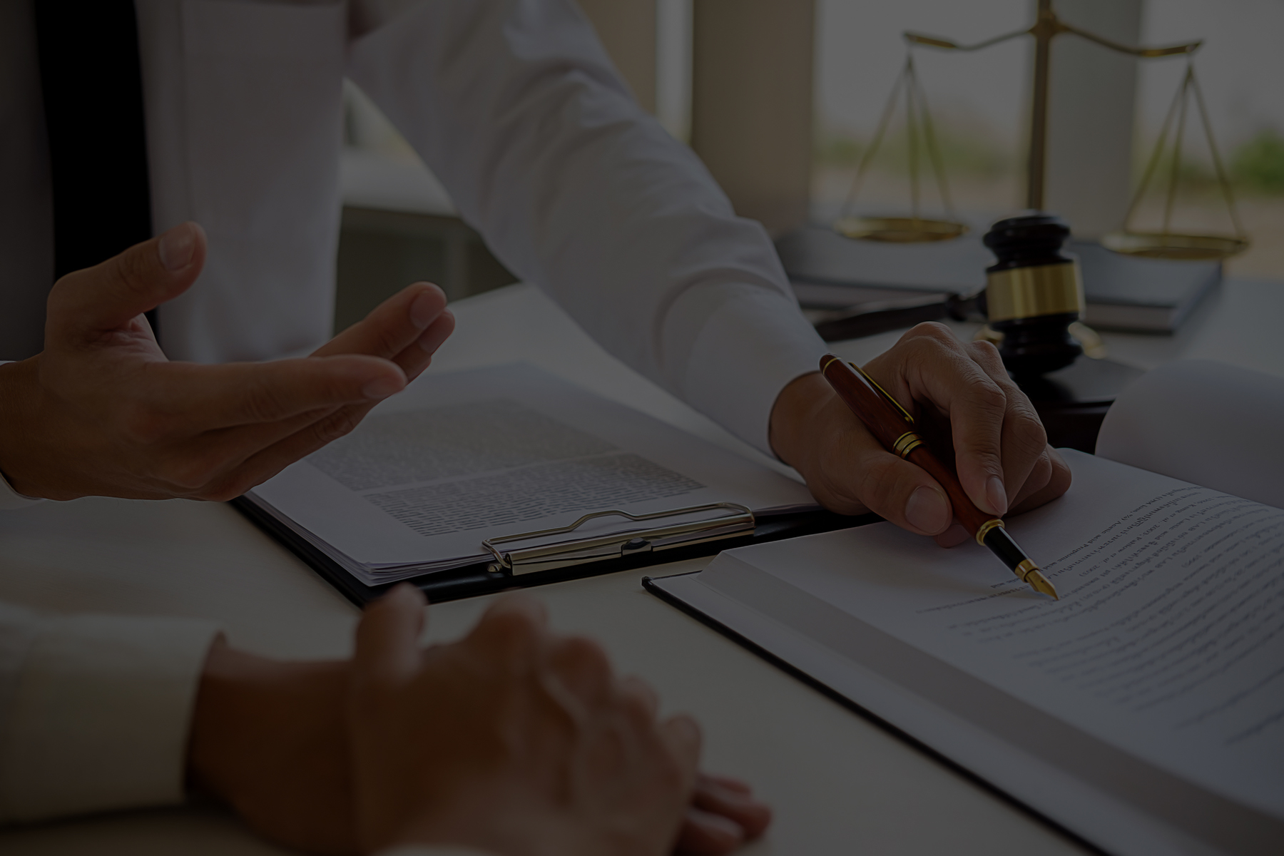 petrarca_law_paperwork2 Lawyer reading a book and showing client where important information is on the page with a ballpoint pen