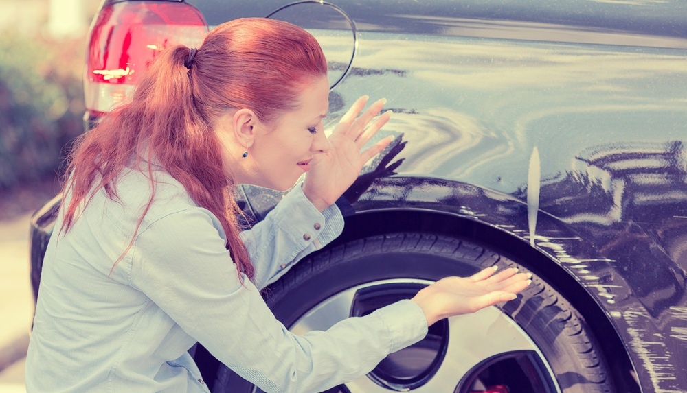 Woman near her car after being in a hit and run accident