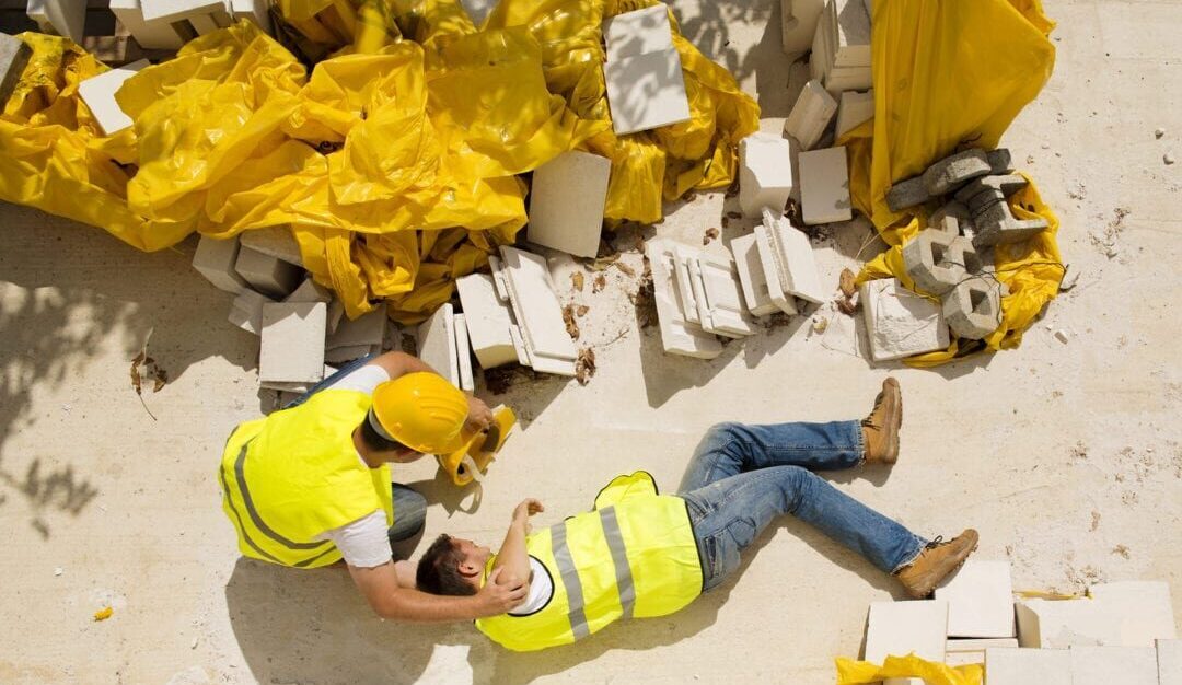 Constuction Accident in RI where man in yellow vest falls from scaffold while another construction worker helps him in Rhode Island