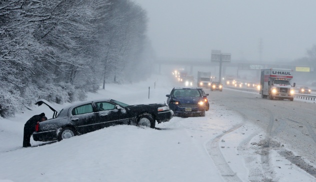 Rhode island winter highway accident where car skidded off the side of the road as traffic passes. Winter driving safety is of the utmost importance in the Northeast