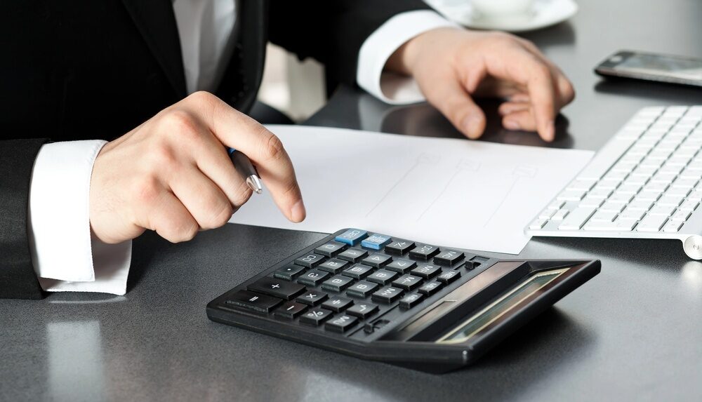 man sitting at a desk using calculator to value a personal injury claim in rhode island