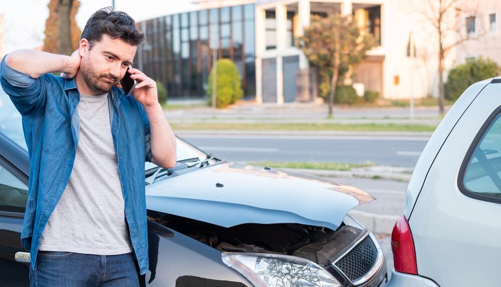 Man with hand on head after a car accident has exceeded his insurance policy limits