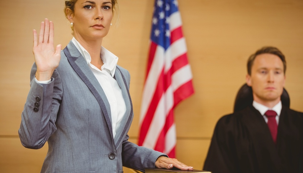 expert witness with hand on bible in front of a judge in a rhode island courtroom