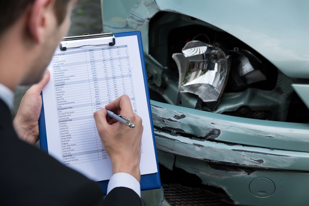 Appraiser taking notes of a car insurance claim denied