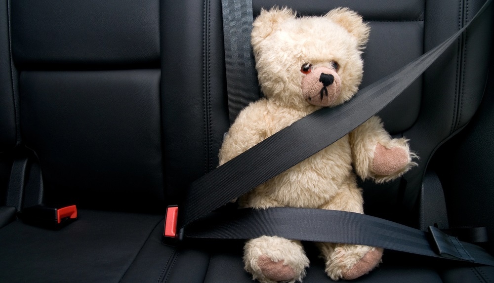 teddy bear buckled in signifying children involved in a car accident